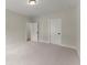 Neutral bedroom with carpet, light walls, and two white doors showing access to a closet and the bathroom at 1419 Coretta Bnd, Atlanta, GA 30318
