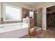 Soaking tub and glass enclosed shower are tiled in this bathroom at 1934 Acorn Ln, Dacula, GA 30019