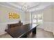 Elegant dining room with tray ceilings, wainscoting, and a modern chandelier at 1934 Acorn Ln, Dacula, GA 30019
