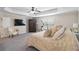 Bright main bedroom with tray ceilings, ceiling fan, sitting area, and exercise machine at 1934 Acorn Ln, Dacula, GA 30019