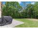 Covered barbecue area and an expanse of green lawn and lush trees in the backyard at 1934 Acorn Ln, Dacula, GA 30019