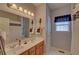 Bright bathroom showcasing double sinks, vanity, and a large mirror and modern lighting at 3020 Crooked Stick Dr, Cumming, GA 30041