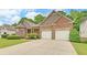 Beautiful brick home featuring a spacious driveway and lush landscaping, great curb appeal at 3020 Crooked Stick Dr, Cumming, GA 30041