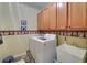 Functional laundry room with a washer, dryer, utility sink, and storage cabinets for added convenience at 3020 Crooked Stick Dr, Cumming, GA 30041
