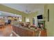 Open-concept living area features hardwood floors, fireplace, and seamless transition to kitchen at 3020 Crooked Stick Dr, Cumming, GA 30041