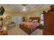 Spacious main bedroom with a tray ceiling, ceiling fan, couch, and access to the outside at 3020 Crooked Stick Dr, Cumming, GA 30041