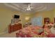 Main bedroom with yellow walls and a ceiling fan and a view of the ensuite and outside through the glass doors at 3020 Crooked Stick Dr, Cumming, GA 30041