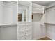 A large closet with custom shelving and drawers with a view of a patterned room at 3020 Parkridge Ne Dr, Brookhaven, GA 30319