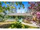Charming ranch-style home featuring a lovely front porch and a beautifully landscaped yard with mature flowering trees at 3020 Parkridge Ne Dr, Brookhaven, GA 30319