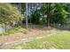 View of the backyard featuring a tree line, a wooden fence and a wooden beam at 4971 Sharp Way, Duluth, GA 30096