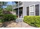 Close up on the front entrance with white railings, a black front door and green bushes surrounding the entrance at 4971 Sharp Way, Duluth, GA 30096