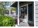 Cozy front porch featuring a small seating area and potted plant with large window and classic dark shutters at 4971 Sharp Way, Duluth, GA 30096