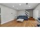 Bright living room with hardwood floors, stairs, neutral walls, a blue sofa and a modern white coffee table at 4971 Sharp Way, Duluth, GA 30096