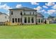 A well-maintained backyard features a lush green lawn, a spacious deck, and a view of the home's exterior at 11305 Knollwood Bend, Johns Creek, GA 30097