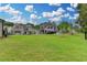 A vast, well-manicured backyard with lush green lawn and a sprinkler system against a backdrop of luxurious homes at 11305 Knollwood Bend, Johns Creek, GA 30097