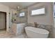 A luxurious bathroom featuring a freestanding tub, glass enclosed shower, and elegant marble tile at 11305 Knollwood Bend, Johns Creek, GA 30097