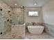 Luxurious bathroom featuring marble walls, a free standing tub, and glass-enclosed shower at 11305 Knollwood Bend, Johns Creek, GA 30097