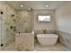 Bright bathroom features a stand alone tub and large glass enclosed shower with marble tile at 11305 Knollwood Bend, Johns Creek, GA 30097