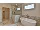 Luxurious bathroom with marble tiling, soaking tub, glass enclosed shower, and walk-in closet at 11305 Knollwood Bend, Johns Creek, GA 30097