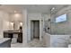 An elegant primary bathroom boasts a seamless glass shower and vanity with gold fixtures and stylish cabinets at 11305 Knollwood Bend, Johns Creek, GA 30097