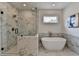 Chic bathroom with a standalone soaking tub, a marble-tiled shower, and large picture window at 11305 Knollwood Bend, Johns Creek, GA 30097