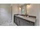 Modern bathroom featuring marble flooring, an elegant grey vanity with gold fixtures, and ample storage space at 11305 Knollwood Bend, Johns Creek, GA 30097