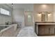 Bright bathroom with marble floors, modern tub, glass shower, and double vanity at 11305 Knollwood Bend, Johns Creek, GA 30097