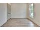 Bright bedroom with hardwood floors, a large window with backyard views, and a closet for ample storage at 11305 Knollwood Bend, Johns Creek, GA 30097