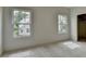 Bedroom featuring neutral carpet, light walls and view of backyard at 11305 Knollwood Bend, Johns Creek, GA 30097