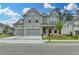 Charming two-story home boasting a brick facade, a well-manicured lawn, and a two-car garage at 11305 Knollwood Bend, Johns Creek, GA 30097