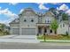 Beautiful two-story home with gray brick, three-car garage, and craftsman style front porch at 11305 Knollwood Bend, Johns Creek, GA 30097