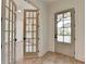 Elegant entryway featuring hardwood floors, a front door with glass inserts, and French doors, creating a grand entrance at 11305 Knollwood Bend, Johns Creek, GA 30097