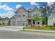 Charming gray brick home boasts a three-car garage and a welcoming front porch with wooden accents at 11305 Knollwood Bend, Johns Creek, GA 30097