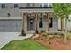 Inviting front porch with wooden supports and elegant lighting fixtures adds to the home's curb appeal at 11305 Knollwood Bend, Johns Creek, GA 30097