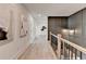 Hallway at the top of stairs featuring gray wall paneling and neutral decor at 11305 Knollwood Bend, Johns Creek, GA 30097