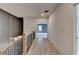 Hallway at the top of stairs with gray wall paneling and doorway to bedroom at 11305 Knollwood Bend, Johns Creek, GA 30097