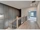 Hallway at the top of stairs features gray wall paneling and an open doorway to another room at 11305 Knollwood Bend, Johns Creek, GA 30097
