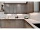 Bright kitchen with gray cabinetry, under cabinet lighting, and white marble backsplash at 11305 Knollwood Bend, Johns Creek, GA 30097