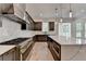 A modern kitchen with stainless steel appliances, gas range, a large island, and beautiful pendant lights at 11305 Knollwood Bend, Johns Creek, GA 30097