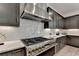 Modern kitchen with gas range, stainless hood, dark cabinets, and white quartz countertops at 11305 Knollwood Bend, Johns Creek, GA 30097