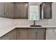 Modern kitchen featuring gray cabinets, quartz countertops, black sink and stainless steel appliances at 11305 Knollwood Bend, Johns Creek, GA 30097