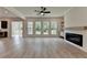 Inviting living room with fireplace, recessed lighting, and a view to the backyard through a bank of windows at 11305 Knollwood Bend, Johns Creek, GA 30097