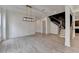 Open-concept living area with a decorative light fixture, staircase, and access to other rooms at 11305 Knollwood Bend, Johns Creek, GA 30097