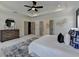 A view of a modern bedroom with a tray ceiling, grey dresser, walk through access, and large patterned rug at 11305 Knollwood Bend, Johns Creek, GA 30097