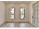 Versatile office space with hardwood floors, natural light from two windows, and a glass-paneled door for a professional setting at 11305 Knollwood Bend, Johns Creek, GA 30097