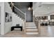 Elegant staircase and a cozy bench in foyer, stylish gray wall paneling detail, leading to kitchen at 11305 Knollwood Bend, Johns Creek, GA 30097