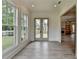 Open sunroom with backyard views, deck access, and continuous wood-look floors at 11305 Knollwood Bend, Johns Creek, GA 30097
