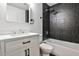Modern bathroom featuring gray tiled shower and white vanity with black hardware at 2195 Penelope Nw St, Atlanta, GA 30314