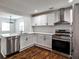 Stylish kitchen with stainless steel appliances and white cabinets, seamlessly connected to the dining area at 2195 Penelope Nw St, Atlanta, GA 30314
