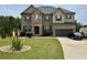 Beautiful two-story home with manicured lawn, stone accents, and attached two-car garage at 292 Aylesbury Blvd, Mcdonough, GA 30252